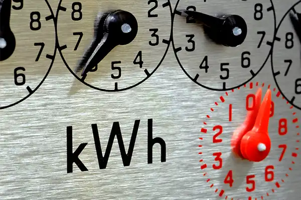 Close-up of an electric meter showing kWh and analog dials